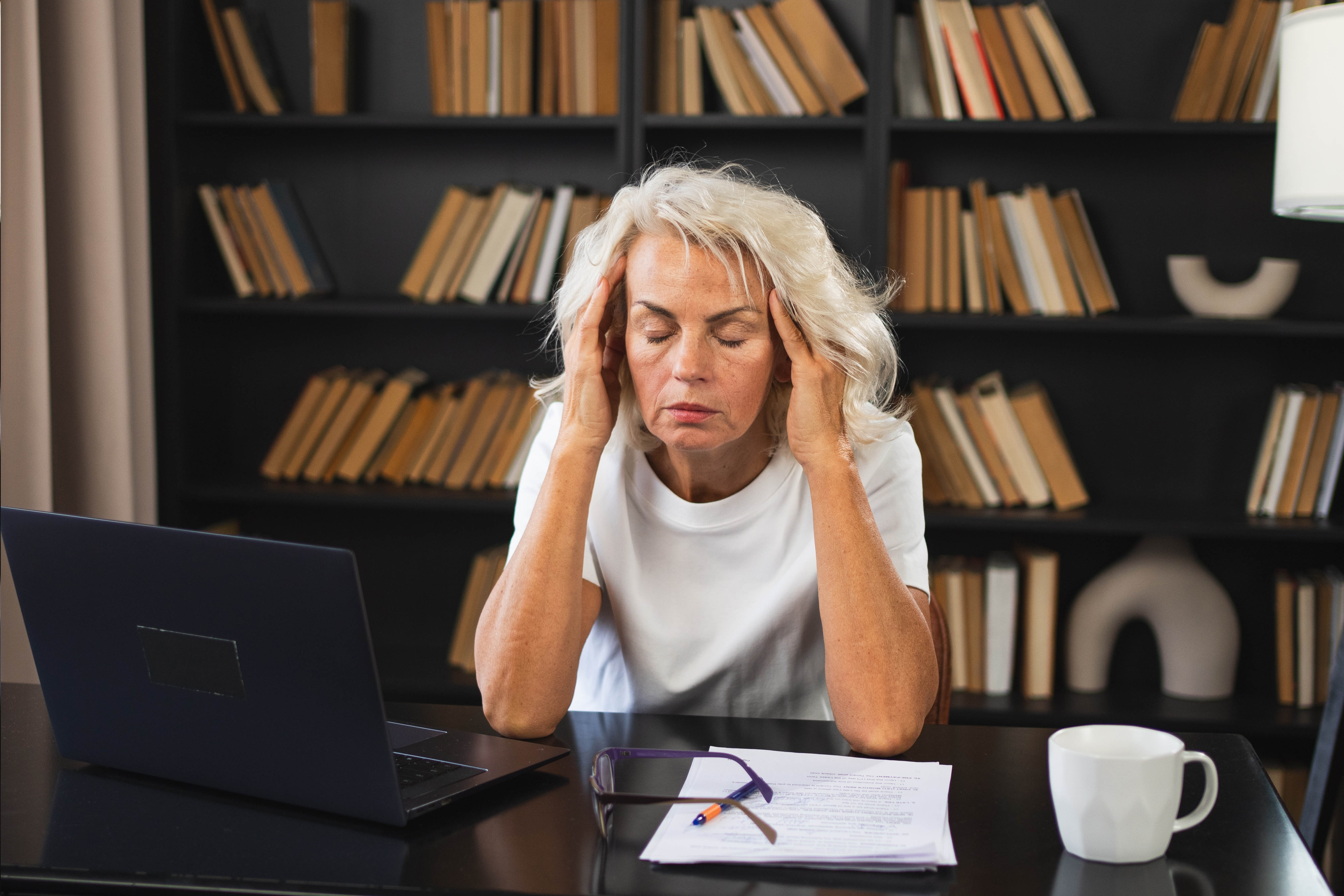 Stressed middle aged woman with her hands on her temples Stressed middle aged woman with her hands on her temples